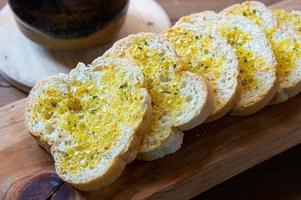 Closeups of garlic bread on chopping board. photo