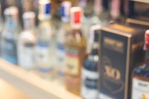 Blurred of wine bottles or different bottles of alcohol. row of alcoholic bottles. photo