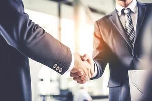 Businessman shaking hands after signing off on a meeting with partners, setting goals, and planning the way to success. Collaborative teamwork photo