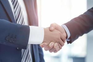 Businessman shaking hands after signing off on a meeting with partners, setting goals, and planning the way to success. Collaborative teamwork photo