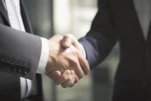 Businessman shaking hands after signing off on a meeting with partners, setting goals, and planning the way to success. Collaborative teamwork photo