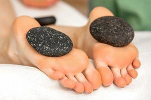 Massage stones on soles feet photo