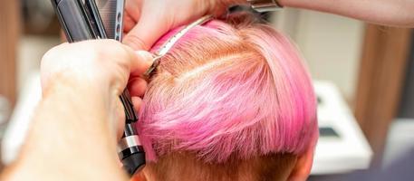 Hairdresser pinches hair with clip photo