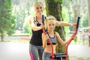 Mother with daughter doing sport exercises photo