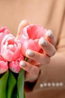 Woman's hands hold pink tulips photo