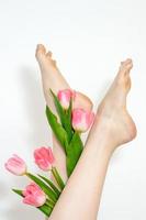 Woman's legs with tulips flowers photo