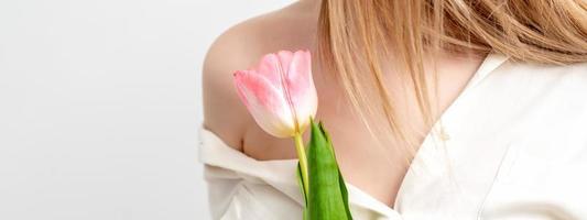 One pink tulip against young female photo