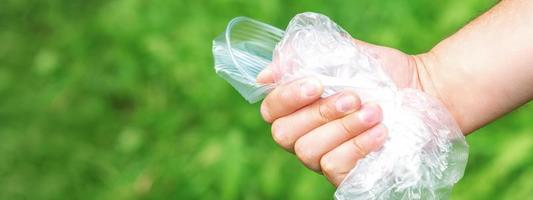 Hand holds crumpled plastic debris photo