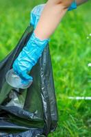 niño pone el plastico en basura bolso foto