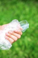 Hand holds crumpled plastic debris photo