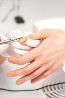 Manicure master is removing cuticles photo