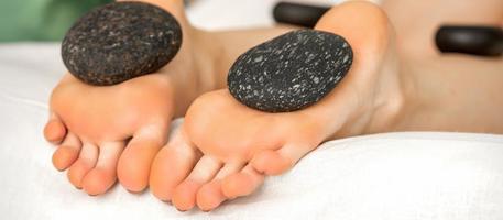 Massage stones on soles feet photo