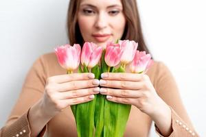 Young woman holds pink tulips photo