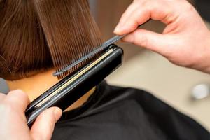 Hairdresser straightening the short hair photo