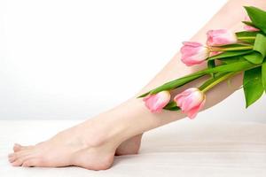 Woman's legs with tulips flowers photo