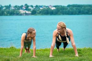 Woman and girl doing push-up exercise photo
