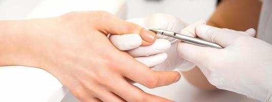 Manicure master is removing cuticles photo