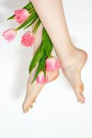 Woman's legs with tulips flowers photo