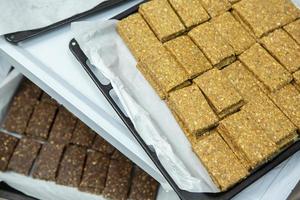 Assortment of cereal or protein bars that leave the assembly line at the factory. Healthy pre or post workout snacks with fruits, nuts and berries. photo