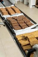 Assortment of cereal or protein bars that leave the assembly line at the factory. Healthy pre or post workout snacks with fruits, nuts and berries. photo