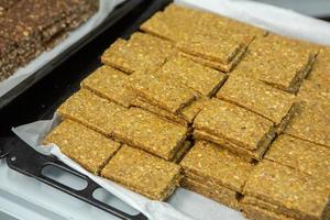 Assortment of cereal or protein bars that leave the assembly line at the factory. Healthy pre or post workout snacks with fruits, nuts and berries. photo