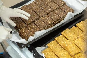 Assortment of cereal or protein bars that leave the assembly line at the factory. Healthy pre or post workout snacks with fruits, nuts and berries. photo