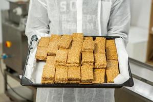 Assortment of cereal or protein bars that leave the assembly line at the factory. Healthy pre or post workout snacks with fruits, nuts and berries. photo