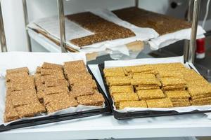 Assortment of cereal or protein bars that leave the assembly line at the factory. Healthy pre or post workout snacks with fruits, nuts and berries. photo