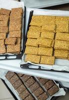 Assortment of cereal or protein bars that leave the assembly line at the factory. Healthy pre or post workout snacks with fruits, nuts and berries. photo