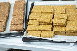 Assortment of cereal or protein bars that leave the assembly line at the factory. Healthy pre or post workout snacks with fruits, nuts and berries. photo
