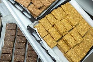 Assortment of cereal or protein bars that leave the assembly line at the factory. Healthy pre or post workout snacks with fruits, nuts and berries. photo