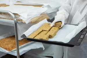 Assortment of cereal or protein bars that leave the assembly line at the factory. Healthy pre or post workout snacks with fruits, nuts and berries. photo