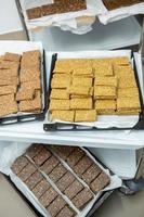 Assortment of cereal or protein bars that leave the assembly line at the factory. Healthy pre or post workout snacks with fruits, nuts and berries. photo