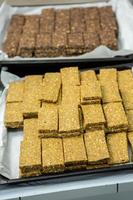 Assortment of cereal or protein bars that leave the assembly line at the factory. Healthy pre or post workout snacks with fruits, nuts and berries. photo