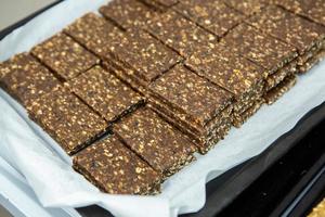 Assortment of cereal or protein bars that leave the assembly line at the factory. Healthy pre or post workout snacks with fruits, nuts and berries. photo