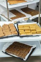 Assortment of cereal or protein bars that leave the assembly line at the factory. Healthy pre or post workout snacks with fruits, nuts and berries. photo