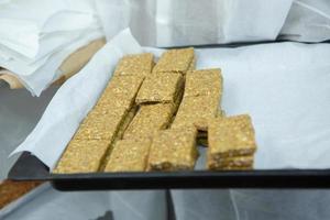 Assortment of cereal or protein bars that leave the assembly line at the factory. Healthy pre or post workout snacks with fruits, nuts and berries. photo
