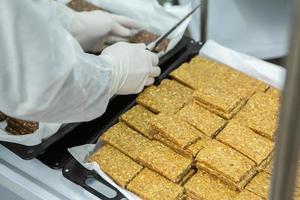 Assortment of cereal or protein bars that leave the assembly line at the factory. Healthy pre or post workout snacks with fruits, nuts and berries. photo