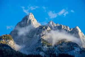 Striking mountain formation under blue sky surrounded by clouds photo