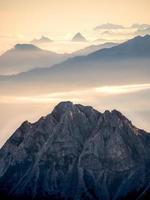 Cold bluish mountain landscape in fog at sunrise photo