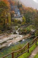 a small village with a stone bridge in autumn rainy weather photo