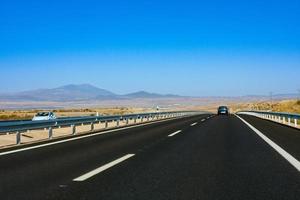 Highway in the middle of the dried fields with mountains in the background. Spain photo