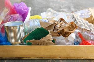 Box with trash on wooden background. photo