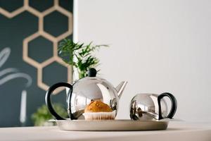 Stainless steel teapot and milk jug in the kitchen. Kitchen accessories photo