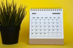 January 2024 month calendar with table plant on yellow cover background. Monthly calendar concept. photo