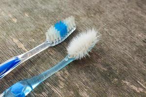 antiguo y nuevo cepillos de dientes en antiguo de madera antecedentes. foto