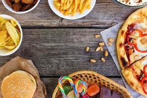 Fast food on old wooden background. Concept of junk eating. Top view. photo