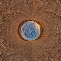 blue sphere little planet inside gravel road or field background. curvature of space photo