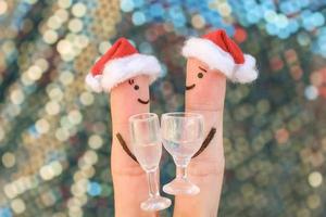 Fingers art of  Happy couple in New Year hats. photo