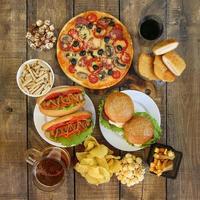 Fast food on old wooden background. Concept of junk eating. Top view. Flat lay. photo